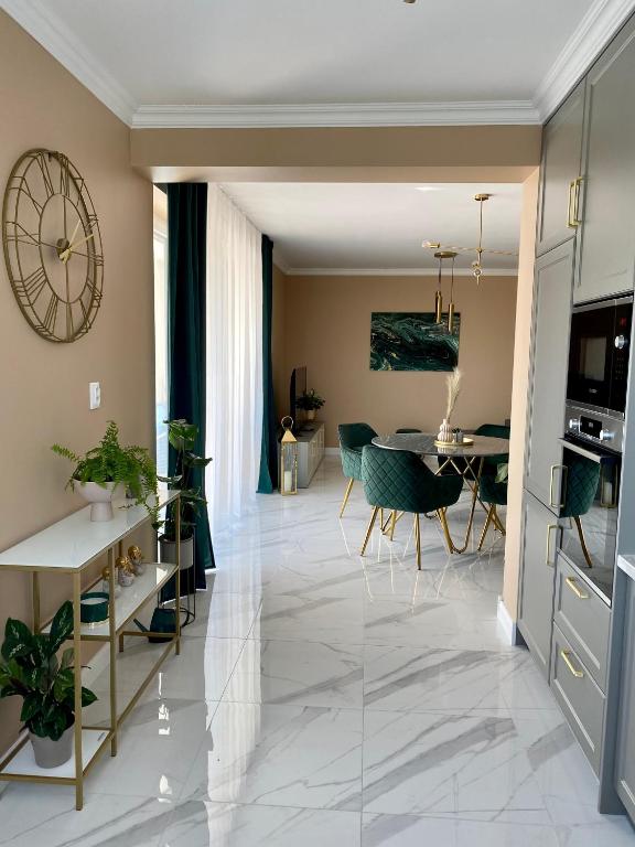 Svetlý apartmán so zelenými stoličkami a mramorovou podlahou